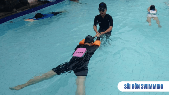 Hình ảnh giáo viên trực tiếp xuống nước hướng dẫn học viên ở lớp học bơi quận 3